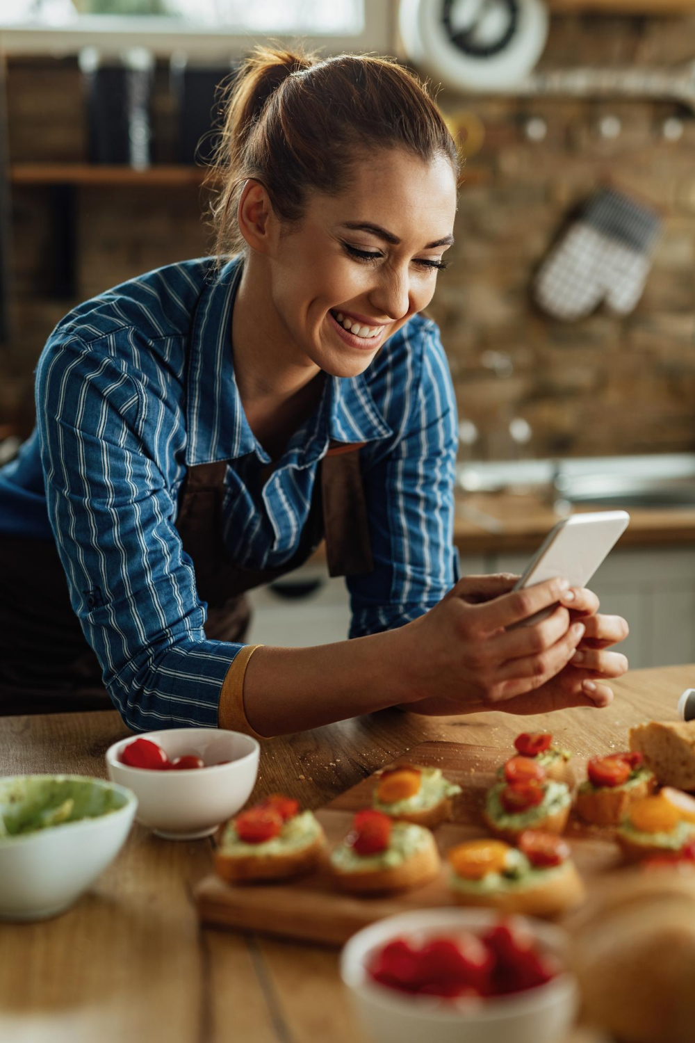 mujer-feliz-usando-telefono-inteligente-fotografiando-comida-que-ha-preparado-cocina